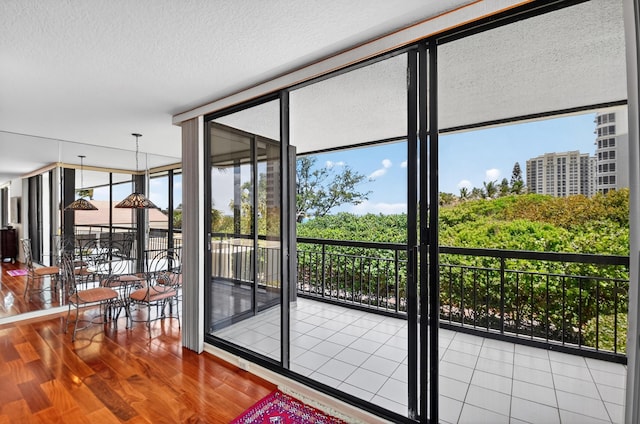 4000 N Ocean Dr Unit 204, Singer Island, FL 33404 - doorway to outside with healthy amount of natural light, wood finished floors, a wall of windows, and a textured ceiling