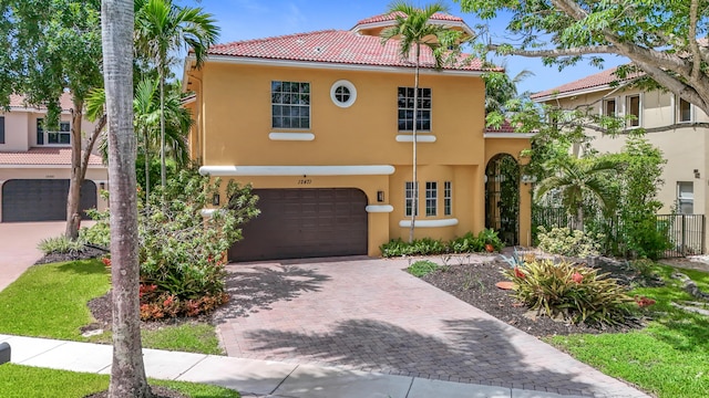 12471 SW 1st St, Plantation, FL 33325 - mediterranean / spanish house featuring stucco siding, decorative driveway, an attached garage, and a tile roof