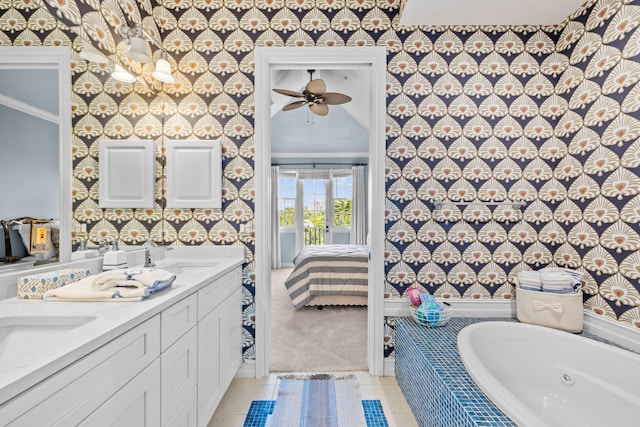 326 Tuxedo Ln, West Palm Beach, FL 33401 - full bath with wallpapered walls, connected bathroom, a jetted tub, double vanity, and tile patterned flooring