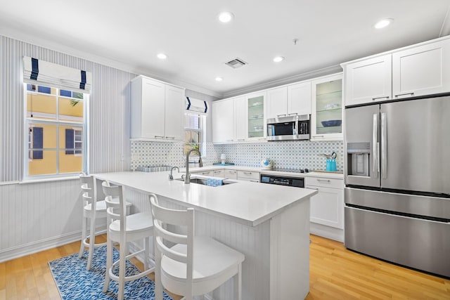 326 Tuxedo Ln, West Palm Beach, FL 33401 - kitchen featuring stainless steel appliances, light wood finished floors, a kitchen breakfast bar, tasteful backsplash, and recessed lighting