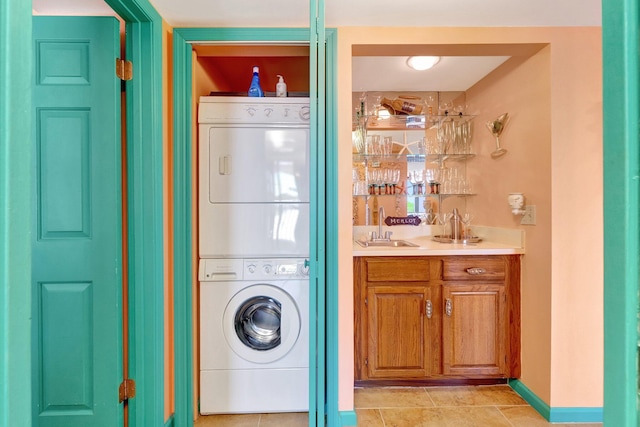 2400 S Ocean Dr Unit 4223, Fort Pierce, FL 34949 - washroom with stacked washing machine and dryer, bar with sink, and light tile patterned flooring