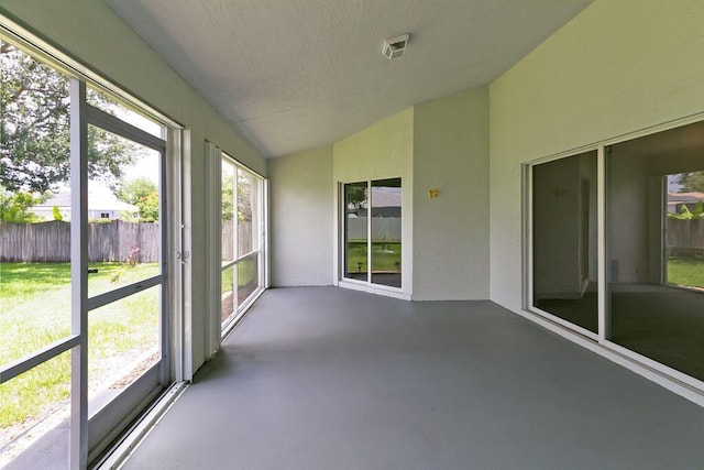 2062 SW Scorpio Ln, Port Saint Lucie, FL 34984 - unfurnished sunroom with vaulted ceiling, finished concrete flooring, and a textured ceiling
