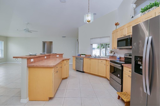 2062 SW Scorpio Ln, Port Saint Lucie, FL 34984 - kitchen with stainless steel appliances, light brown cabinets, and light tile patterned floors