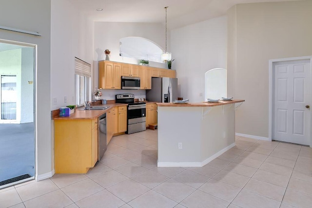 2062 SW Scorpio Ln, Port Saint Lucie, FL 34984 - kitchen with appliances with stainless steel finishes, high vaulted ceiling, light brown cabinetry, light tile patterned floors, and light countertops