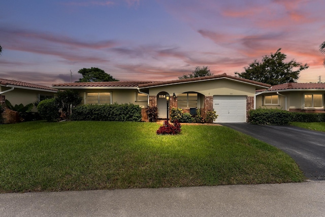1261 NW 44th St, Deerfield Beach, FL 33064 - ranch-style house featuring an attached garage, asphalt driveway, a front lawn, stucco siding, and a tiled roof
