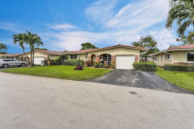 1261 NW 44th St, Deerfield Beach, FL 33064 - view of front facade featuring an attached garage, a front lawn, asphalt driveway, a tiled roof, and stucco siding