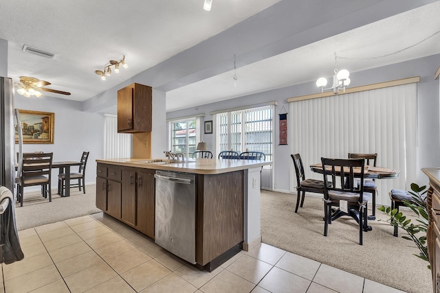 1261 NW 44th St, Deerfield Beach, FL 33064 - kitchen featuring light colored carpet, stainless steel dishwasher, light tile patterned flooring, dark brown cabinetry, and a chandelier