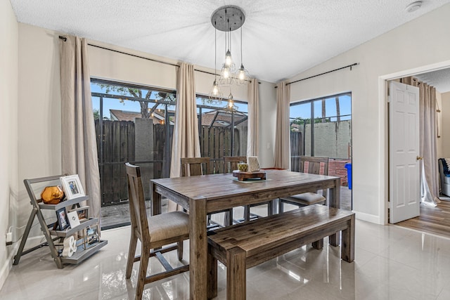 241 Meadows Dr Unit 241, Boynton Beach, FL 33436 - dining space with plenty of natural light, a textured ceiling, light tile patterned flooring, lofted ceiling, and a chandelier