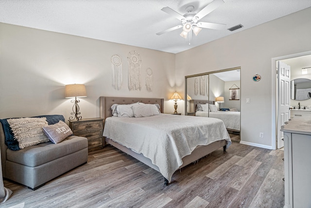 241 Meadows Dr Unit 241, Boynton Beach, FL 33436 - bedroom featuring wood finished floors, a closet, a ceiling fan, and ensuite bath