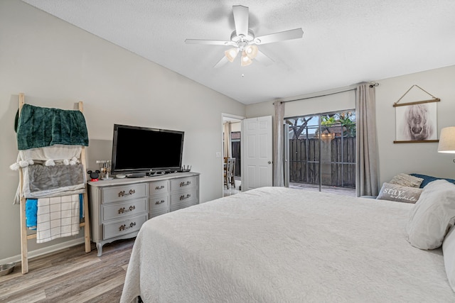 241 Meadows Dr Unit 241, Boynton Beach, FL 33436 - bedroom with access to outside, wood finished floors, lofted ceiling, a textured ceiling, and a ceiling fan