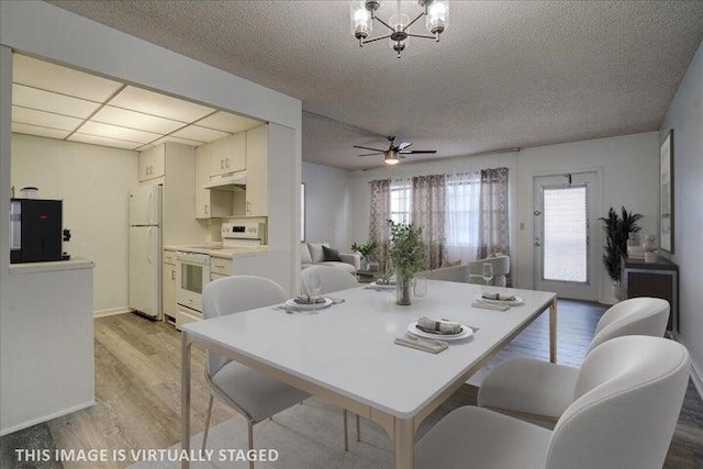 4110 Newport U Unit 4110, Deerfield Beach, FL 33442 - dining space featuring light wood-style floors, a textured ceiling, a ceiling fan, and a chandelier