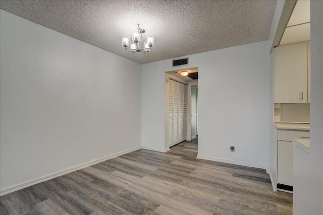 4110 Newport U Unit 4110, Deerfield Beach, FL 33442 - unfurnished dining area with light wood-style flooring, a chandelier, and a textured ceiling