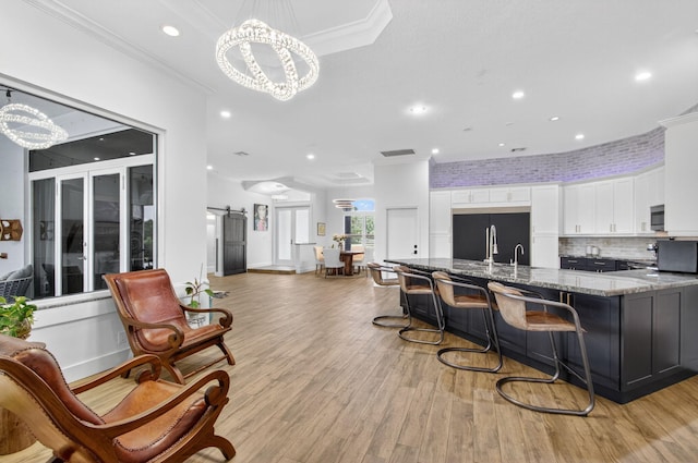 4315 Caryota Dr, Boynton Beach, FL 33436 - kitchen with black refrigerator, a chandelier, stainless steel microwave, white cabinets, and recessed lighting