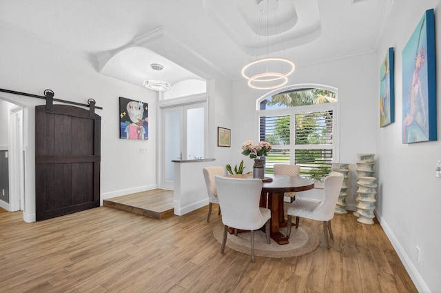 4315 Caryota Dr, Boynton Beach, FL 33436 - dining area with a raised ceiling, wood finished floors, a chandelier, a barn door, and crown molding