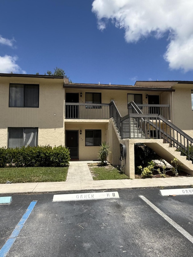 21950 Soundview Ter Unit 107, Boca Raton, FL 33433 - view of building exterior featuring stairs and uncovered parking