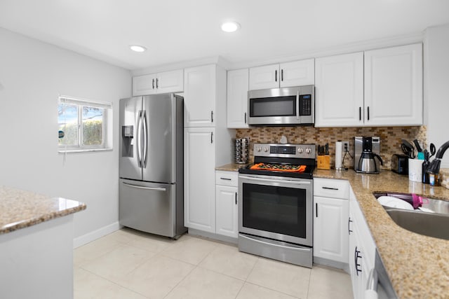 7750 NW 50th St Unit 106, Lauderhill, FL 33351 - kitchen with stainless steel appliances, white cabinets, backsplash, recessed lighting, and light stone countertops