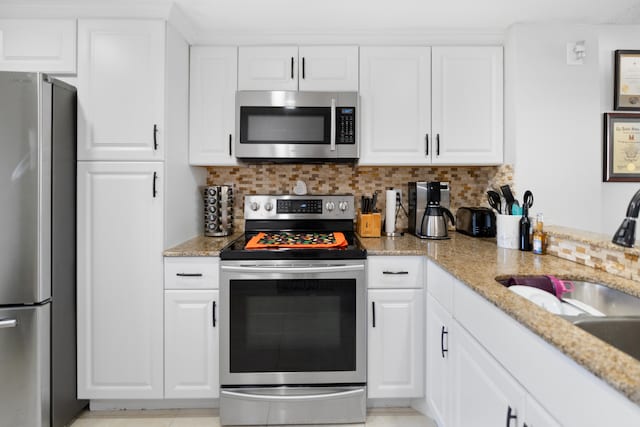 7750 NW 50th St Unit 106, Lauderhill, FL 33351 - kitchen with stainless steel appliances, white cabinetry, and tasteful backsplash