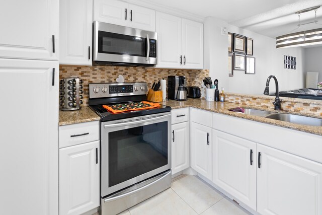 7750 NW 50th St Unit 106, Lauderhill, FL 33351 - kitchen featuring appliances with stainless steel finishes, tasteful backsplash, light tile patterned floors, and light stone countertops
