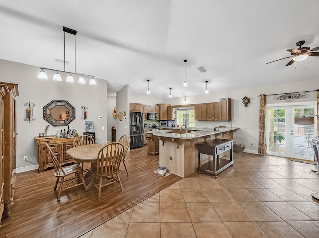 5301 Bald Cypress Trl, Fort Pierce, FL 34951 - kitchen with fridge with ice dispenser, a peninsula, a breakfast bar area, and healthy amount of natural light