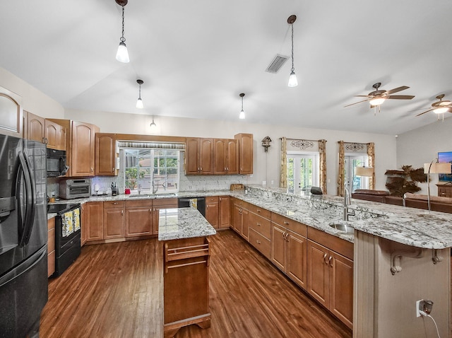 5301 Bald Cypress Trl, Fort Pierce, FL 34951 - kitchen featuring black appliances, dark wood-style floors, a peninsula, a ceiling fan, and plenty of natural light