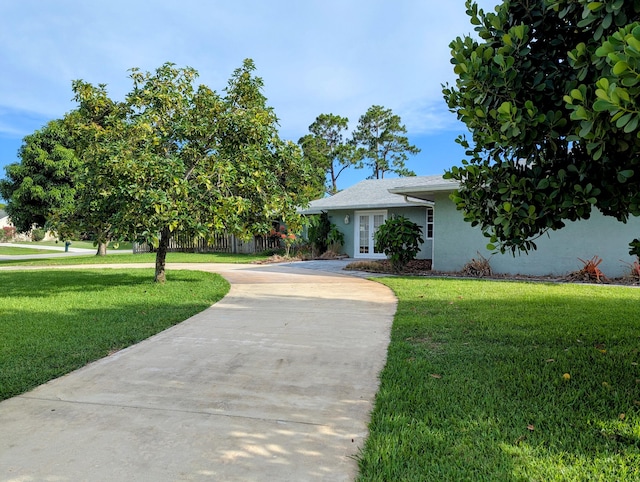 3074 SE Dalhart Rd, Port Saint Lucie, FL 34952 - view of front facade featuring stucco siding, driveway, and a front lawn