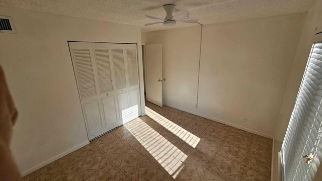 206 Foxtail Dr Unit D1, Greenacres, FL 33415 - unfurnished bedroom featuring a textured ceiling, a closet, tile patterned floors, and a ceiling fan