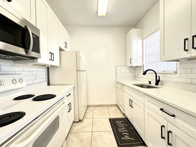 751 Cypress Ln Unit K, Deerfield Beach, FL 33064 - kitchen with white appliances, white cabinetry, a textured ceiling, tasteful backsplash, and light tile patterned flooring