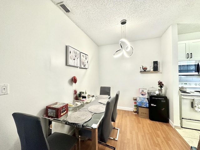 751 Cypress Ln Unit K, Deerfield Beach, FL 33064 - dining space with a textured ceiling and light wood-type flooring