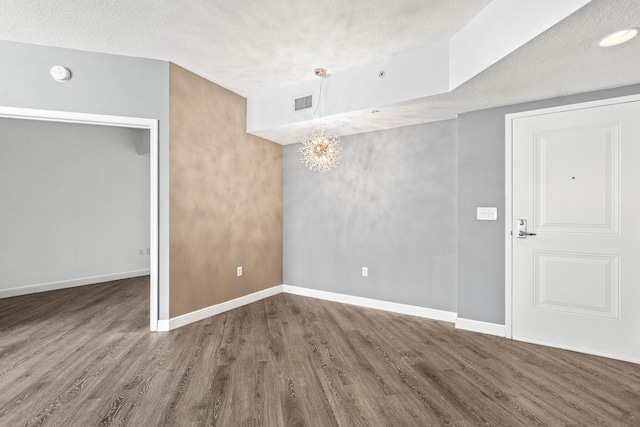 350 N Federal Hwy Unit 609, Boynton Beach, FL 33435 - unfurnished room featuring a smoke detector, wood finished floors, a textured ceiling, and a chandelier