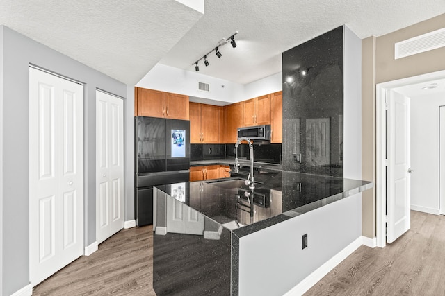 350 N Federal Hwy Unit 609, Boynton Beach, FL 33435 - kitchen with refrigerator, light wood-type flooring, stainless steel microwave, a peninsula, and brown cabinetry