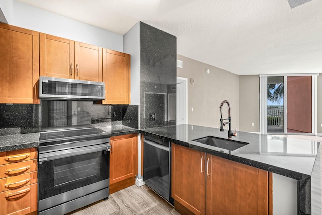 350 N Federal Hwy Unit 609, Boynton Beach, FL 33435 - kitchen featuring stainless steel appliances, a peninsula, backsplash, light wood-type flooring, and dark stone countertops