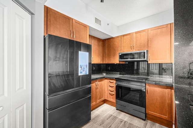 350 N Federal Hwy Unit 609, Boynton Beach, FL 33435 - kitchen with appliances with stainless steel finishes, light wood-style floors, tasteful backsplash, and brown cabinetry