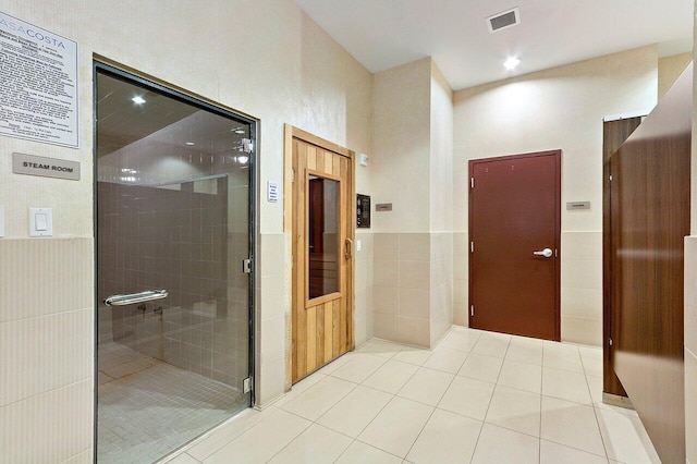 350 N Federal Hwy Unit 609, Boynton Beach, FL 33435 - bathroom featuring tile walls, tile patterned floors, a stall shower, and wainscoting
