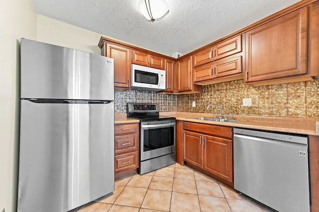15054 Ashland Way Unit 84, Delray Beach, FL 33484 - kitchen with appliances with stainless steel finishes, light countertops, light tile patterned floors, tasteful backsplash, and a textured ceiling