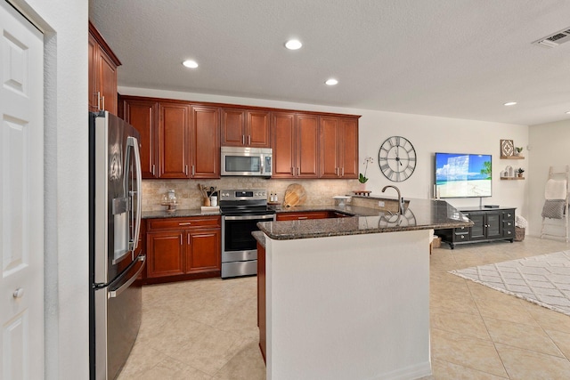 709 SW Sun Cir, Palm City, FL 34990 - kitchen with appliances with stainless steel finishes, decorative backsplash, light tile patterned flooring, dark stone countertops, and recessed lighting
