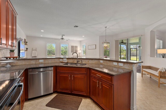 709 SW Sun Cir, Palm City, FL 34990 - kitchen with stainless steel appliances, light tile patterned floors, dark stone countertops, a ceiling fan, and recessed lighting