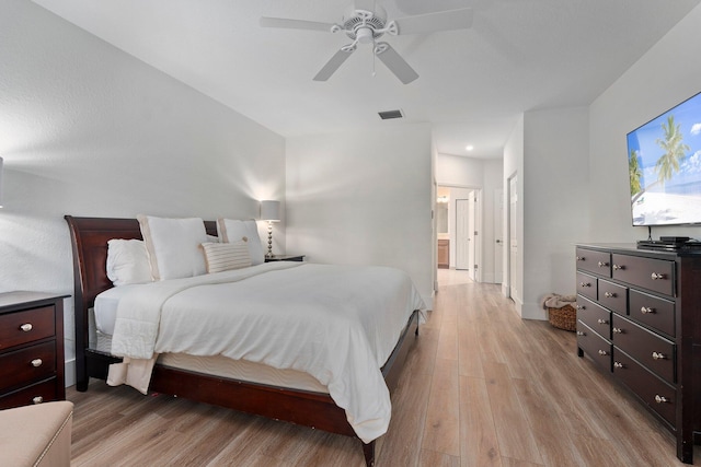 709 SW Sun Cir, Palm City, FL 34990 - bedroom with light wood-type flooring, ceiling fan, and ensuite bathroom