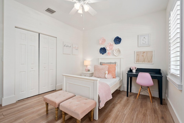 709 SW Sun Cir, Palm City, FL 34990 - bedroom with light wood-type flooring, multiple windows, a closet, and a ceiling fan
