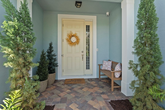 709 SW Sun Cir, Palm City, FL 34990 - view of exterior entry featuring stucco siding and a surveillance system