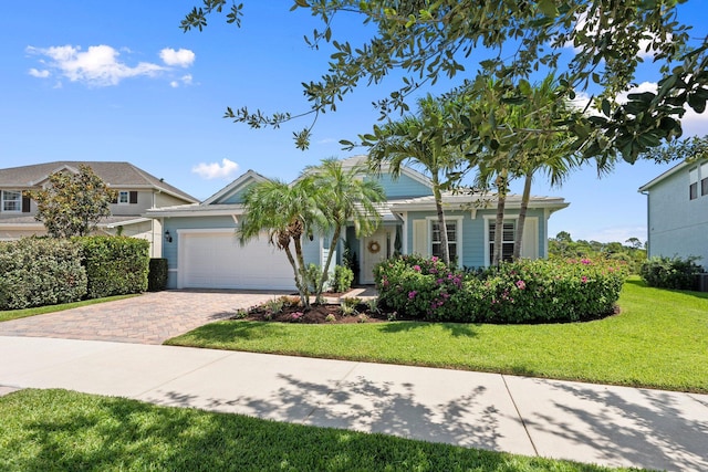 709 SW Sun Cir, Palm City, FL 34990 - view of front facade featuring a front yard, an attached garage, and decorative driveway