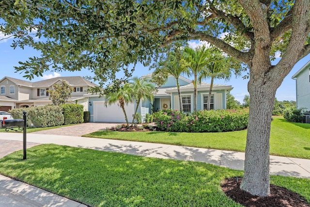 709 SW Sun Cir, Palm City, FL 34990 - view of front facade featuring a front lawn, decorative driveway, and a garage