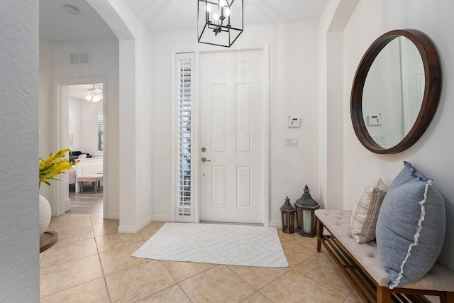 709 SW Sun Cir, Palm City, FL 34990 - foyer entrance featuring arched walkways, light tile patterned flooring, and a chandelier