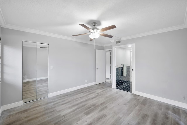 512 Shady Pine Way Unit B1, Greenacres, FL 33415 - unfurnished bedroom with wood finished floors, a textured ceiling, ornamental molding, a closet, and ceiling fan
