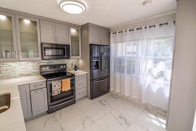 8129 Sedgewick Ct Unit 29-A, Lake Clarke Shores, FL 33406 - kitchen featuring appliances with stainless steel finishes, gray cabinets, backsplash, light marble finish flooring, and a textured ceiling