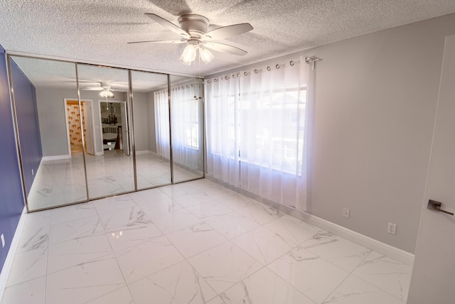 8129 Sedgewick Ct Unit 29-A, Lake Clarke Shores, FL 33406 - unfurnished bedroom featuring light marble finish flooring, a textured ceiling, and a ceiling fan