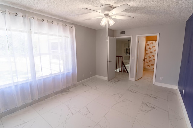 8129 Sedgewick Ct Unit 29-A, Lake Clarke Shores, FL 33406 - unfurnished bedroom with a textured ceiling, marble look tile flooring, a ceiling fan, and ensuite bathroom