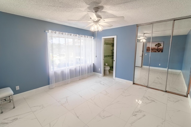 8129 Sedgewick Ct Unit 29-A, Lake Clarke Shores, FL 33406 - unfurnished bedroom featuring a textured ceiling, a closet, a ceiling fan, ensuite bathroom, and marble finish flooring