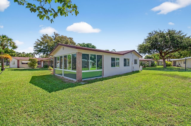 2520 SW Natura Blvd, Deerfield Beach, FL 33441 - rear view of property featuring a yard, stucco siding, and a sunroom