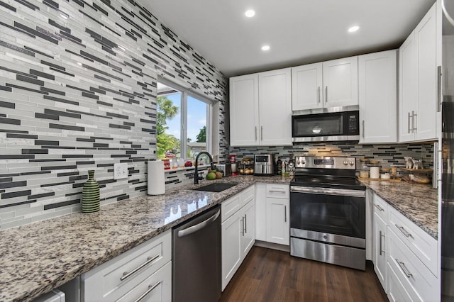 2520 SW Natura Blvd, Deerfield Beach, FL 33441 - kitchen with appliances with stainless steel finishes, decorative backsplash, white cabinetry, dark wood-type flooring, and recessed lighting