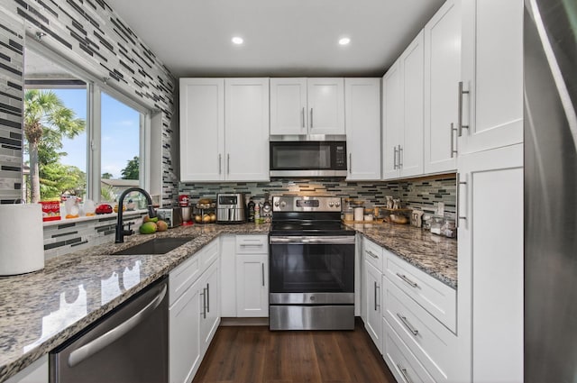 2520 SW Natura Blvd, Deerfield Beach, FL 33441 - kitchen featuring appliances with stainless steel finishes, backsplash, white cabinetry, dark wood finished floors, and recessed lighting